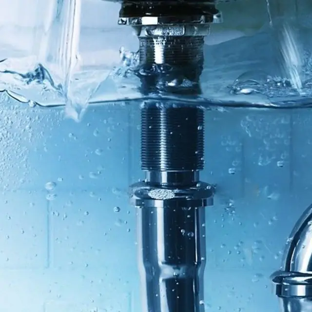 Siphon et conduite d'évacuation d'eau sous un lavabo